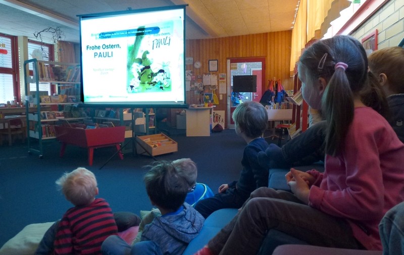 Kinder schauen in der Bücherhalle ein Bilderbuchkino an